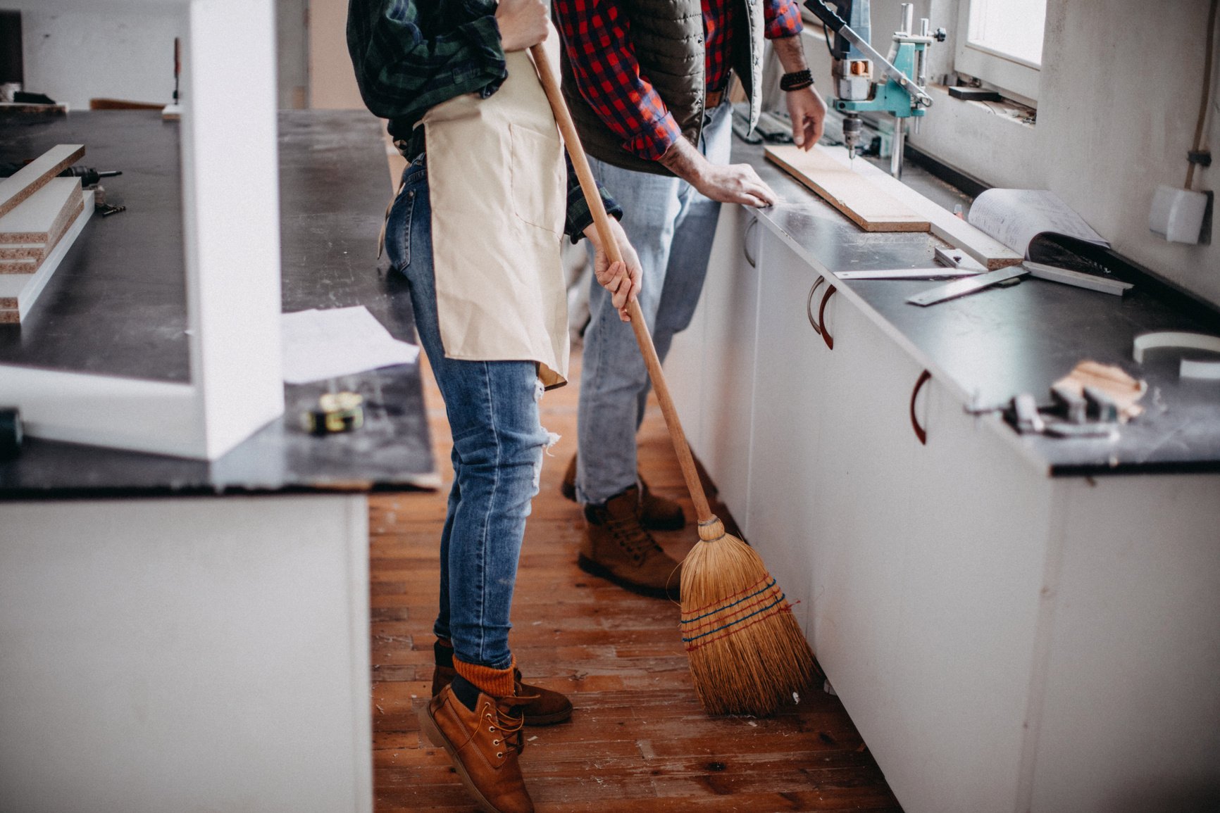 Young  couple cleaning a construction workshop